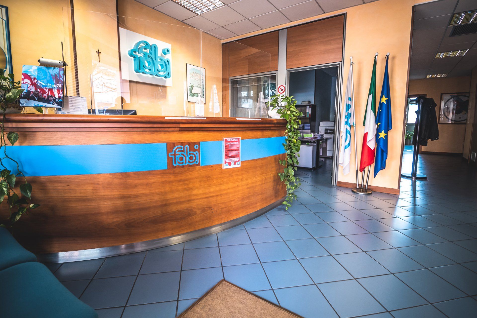 Un atrio con una scrivania in legno e bandiere sul pavimento