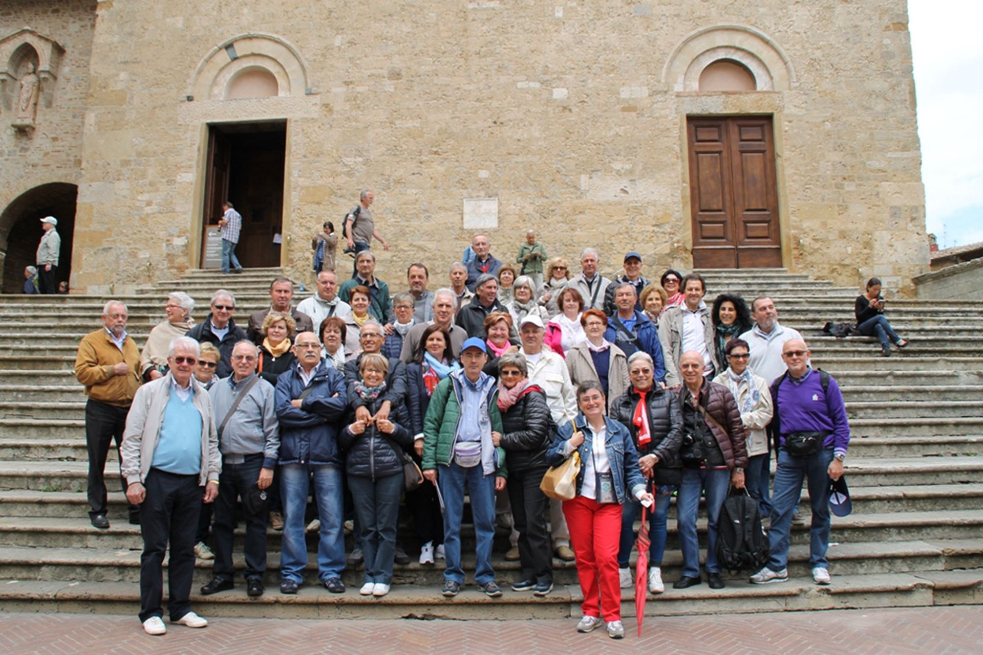 Un gruppo di persone posa per una foto davanti a un edificio.