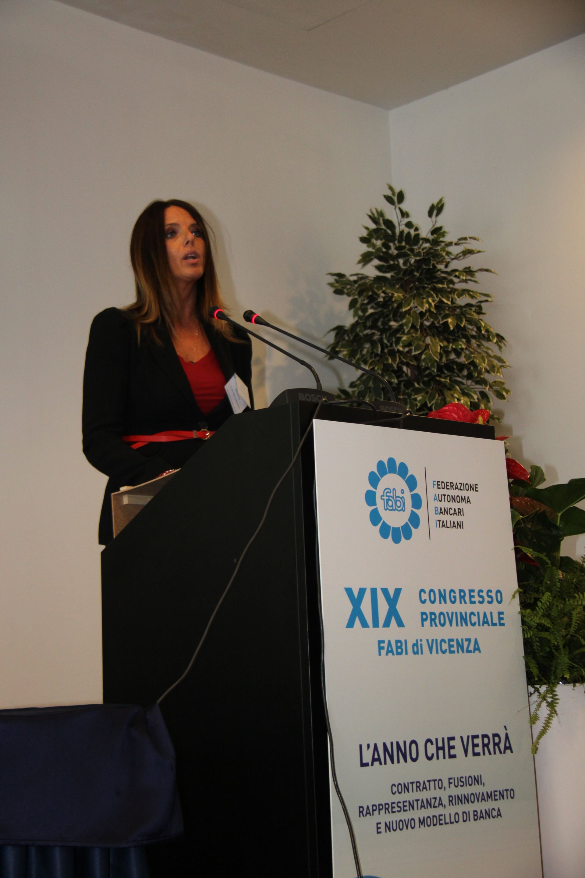 Una donna sta su un podio con un cartello che dice xix