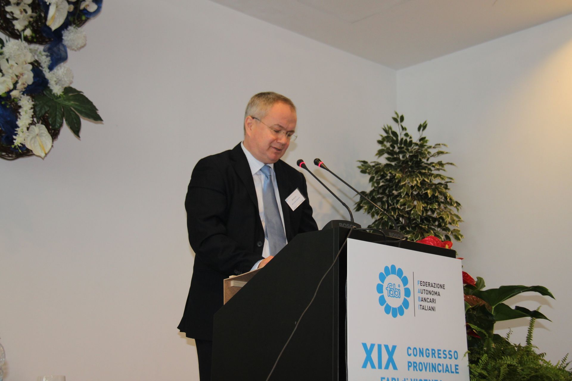 Un uomo sta su un podio con un cartello che dice xix