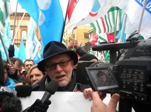 Un uomo con un cappello viene intervistato da una telecamera