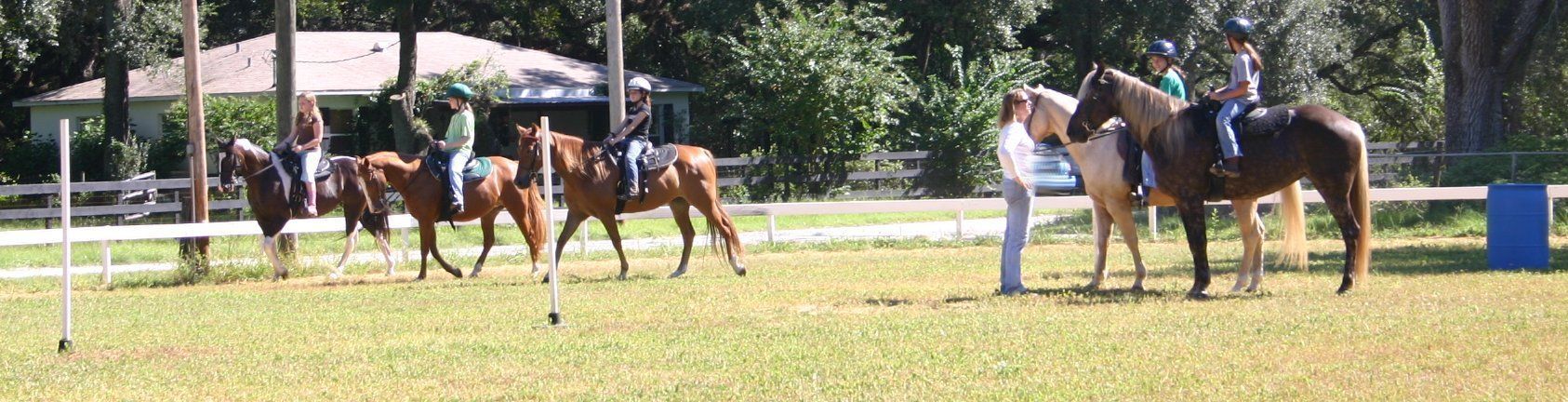 A group of people are riding horses in a field.