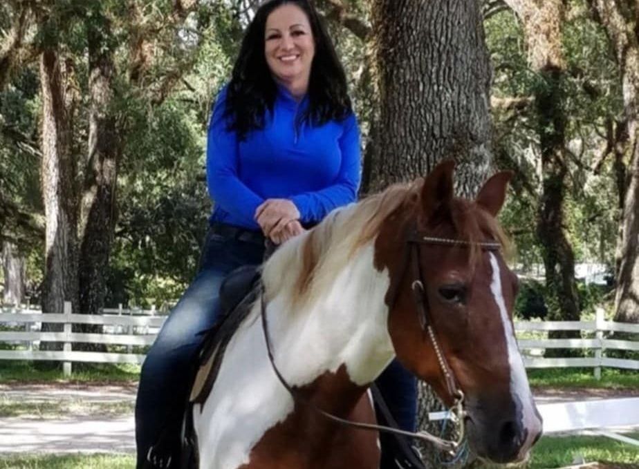 A group of people are riding horses in a field.
