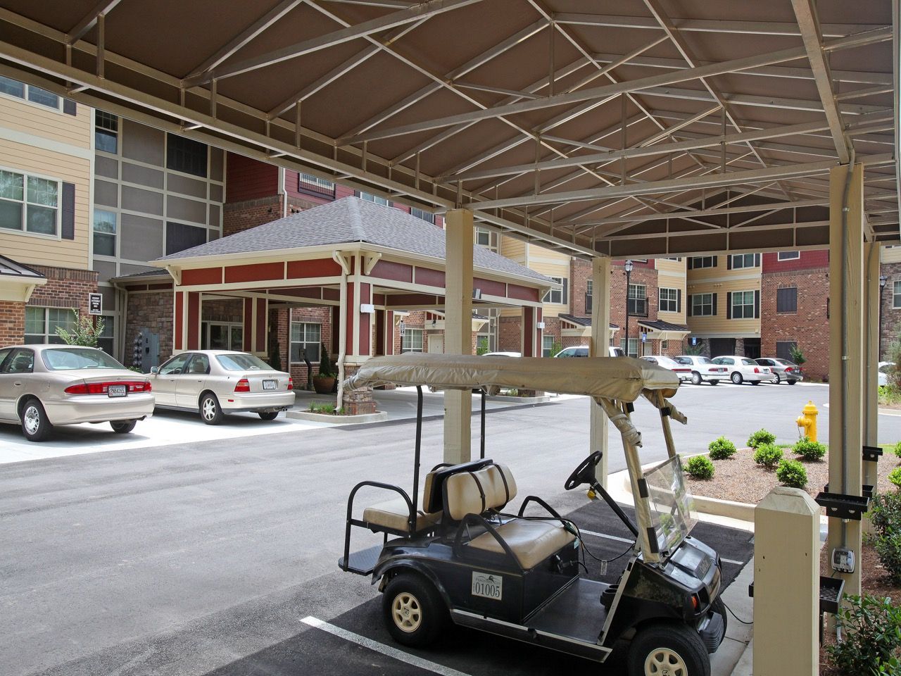 Covered drop-off area with a golf cart and building exterior in the background.