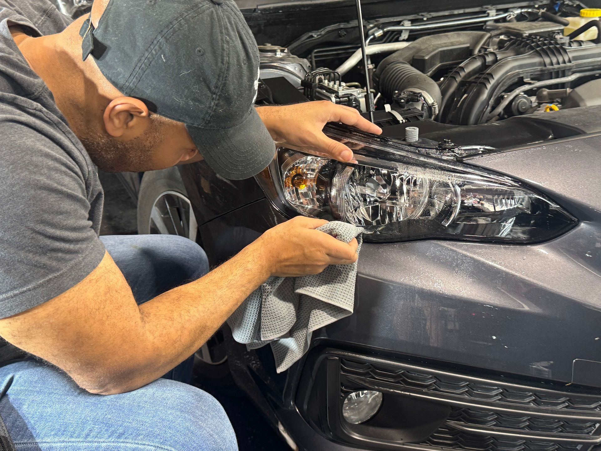 A person wearing black gloves is touching a tire