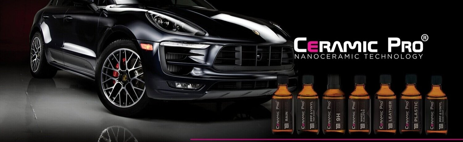 A black car is sitting next to a row of bottles of ceramic pro.
