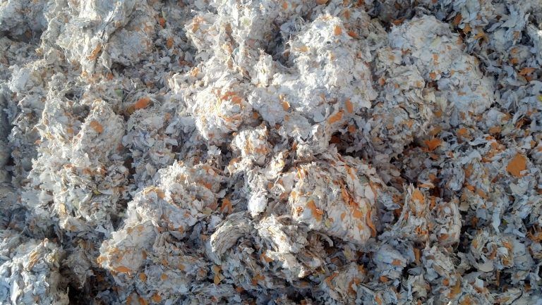 A close up of a pile of white and orange shredded paper.