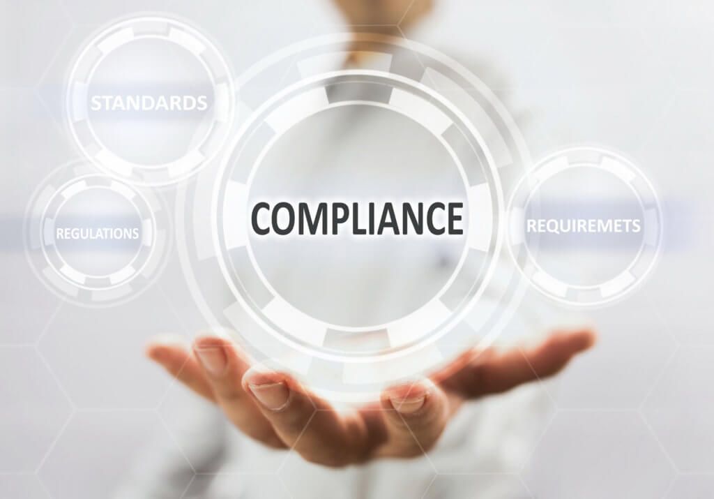 A person is holding a virtual screen with the word compliance on it.