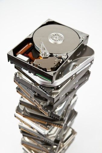 Tall stack of hard drives on a white background