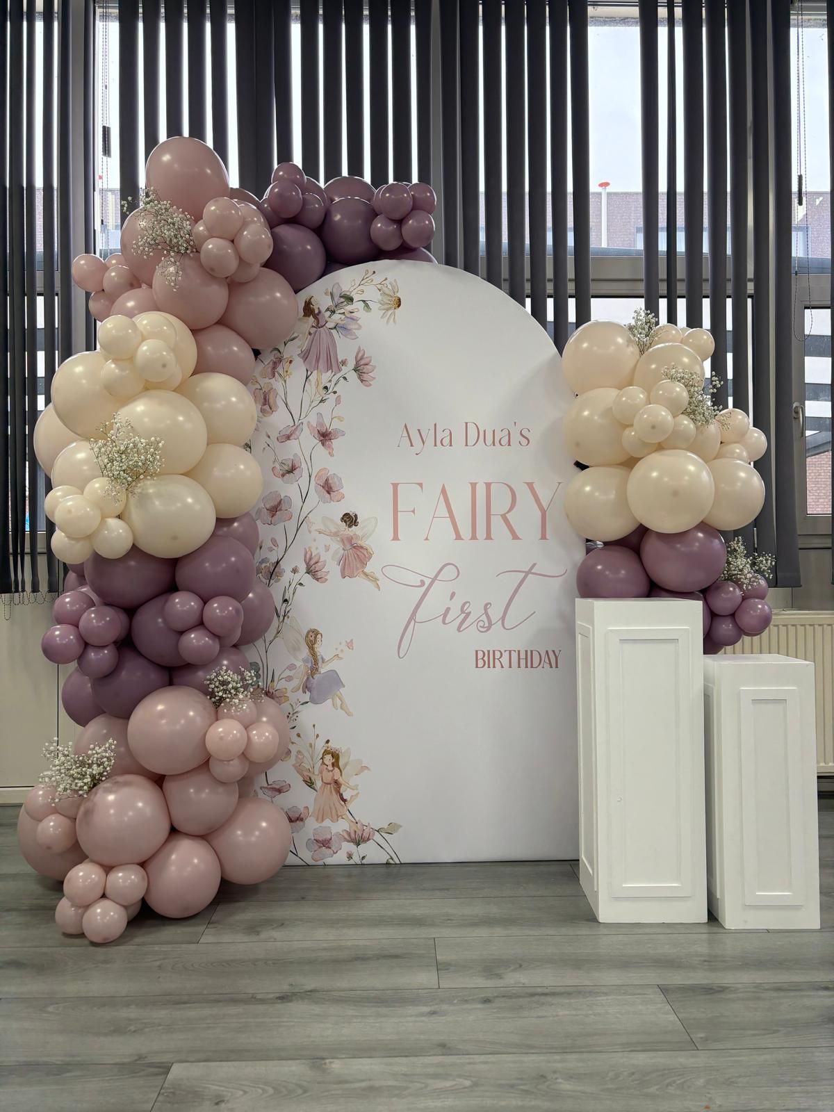 Een kamer versierd met ballonnen en bloemen voor een babyshower.