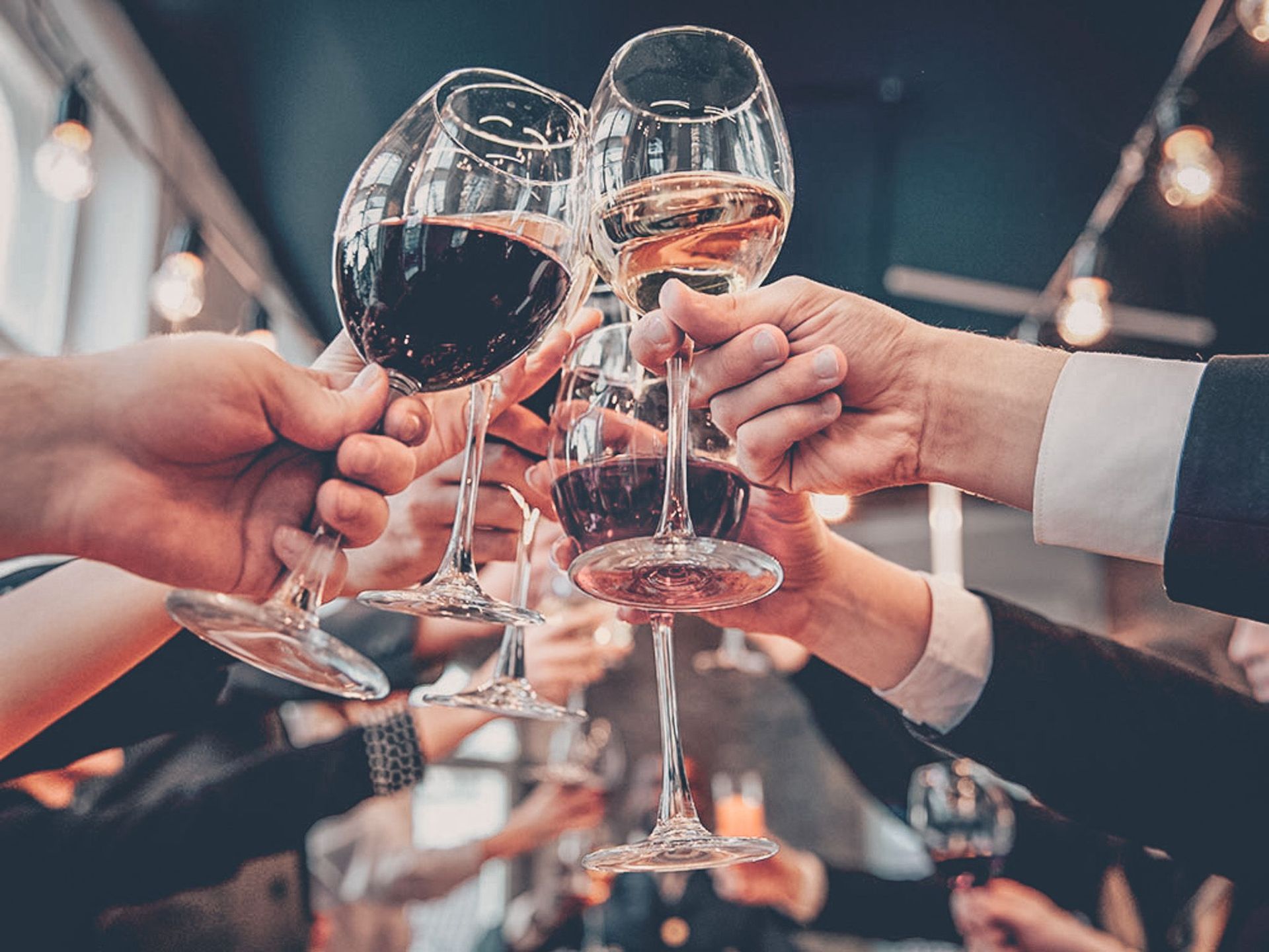 Een groep mensen brengt een toost uit met wijnglazen.