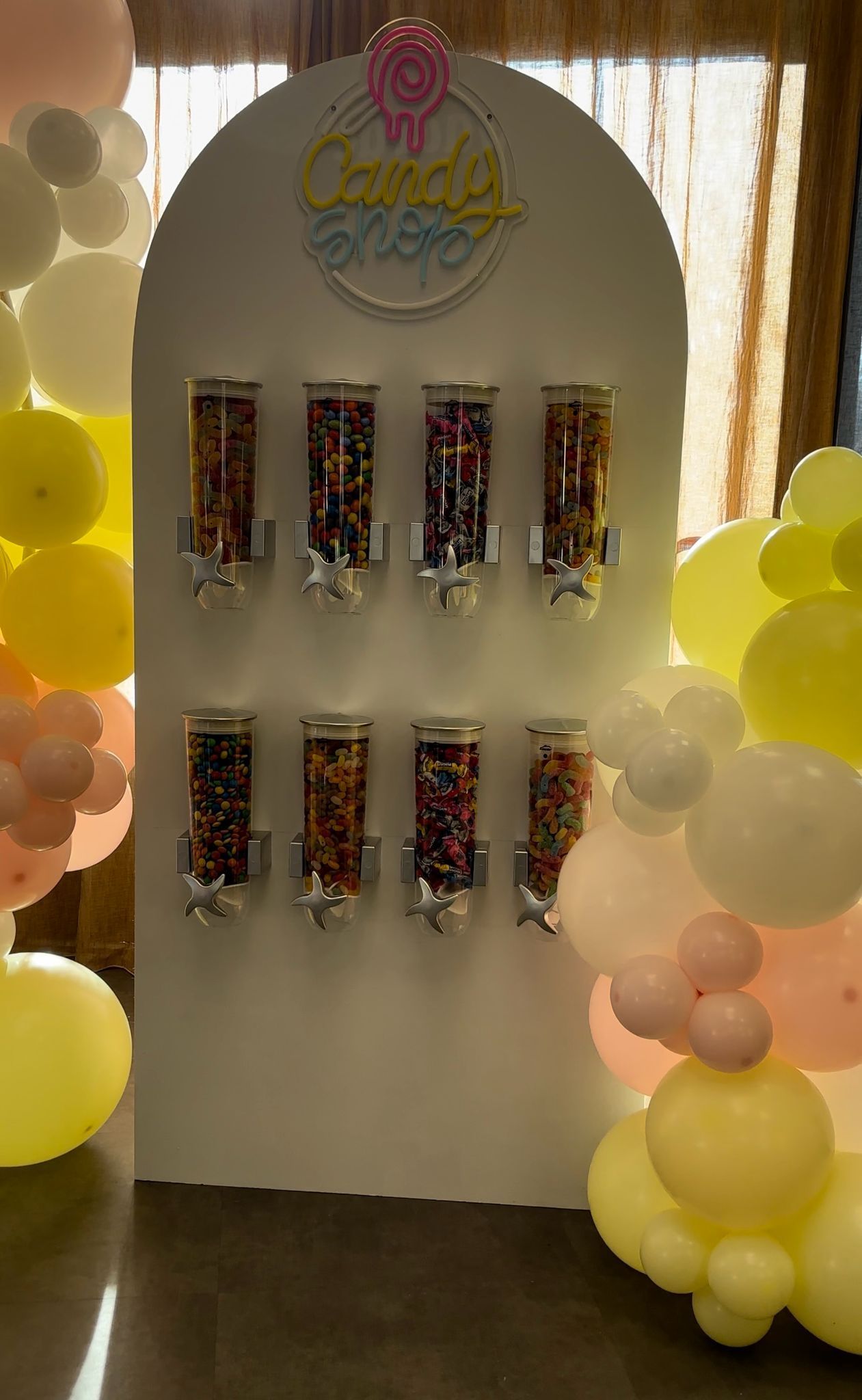 Een muur vol met potten snoep en ballonnen.
