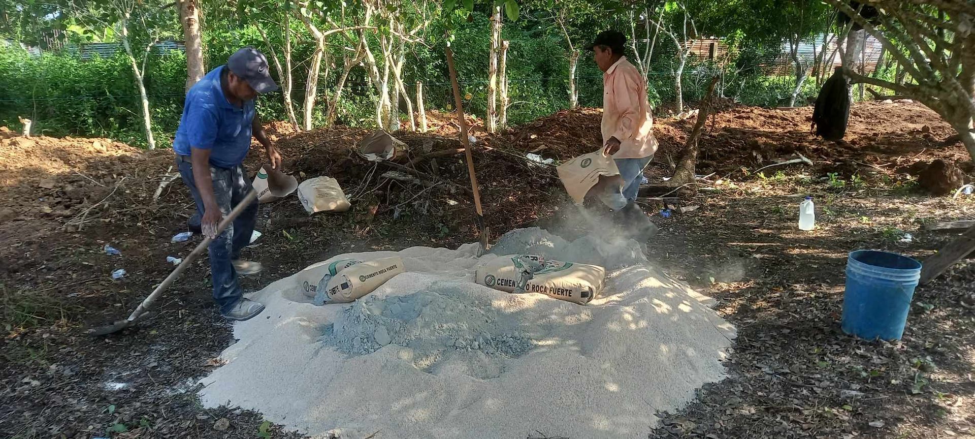 a group of people are working on a pile of dirt .