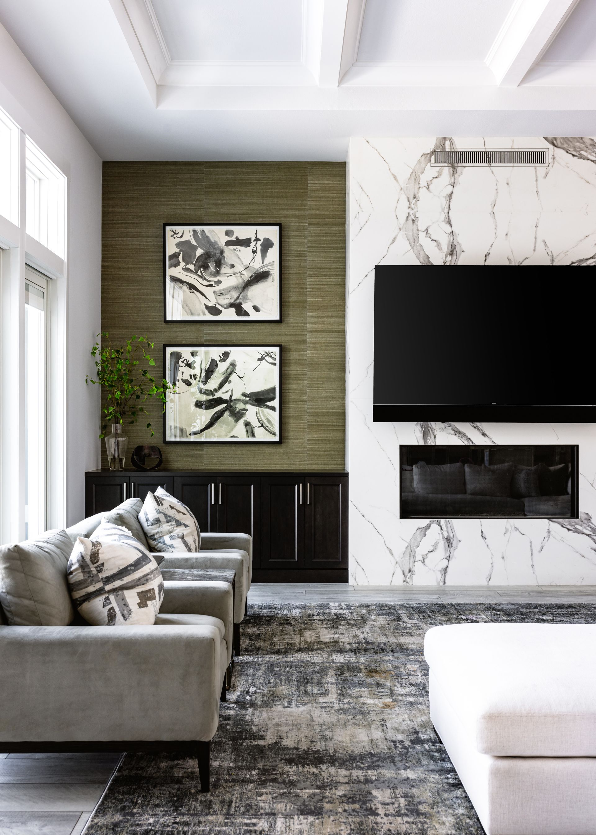 Living room with gray sofa, marble fireplace, and abstract art.