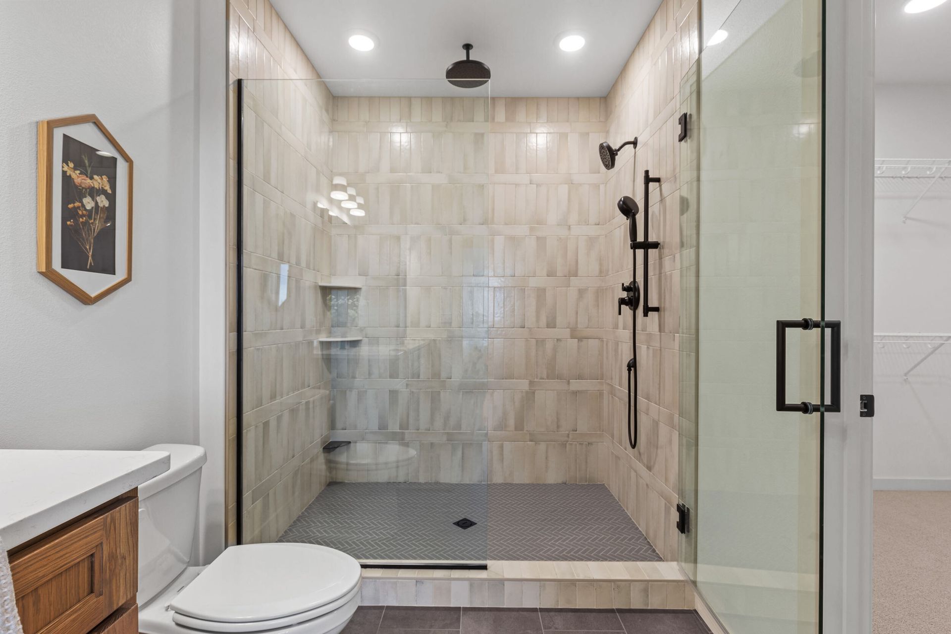 Modern bathroom with a glass-enclosed shower, white walls, and a toilet.
