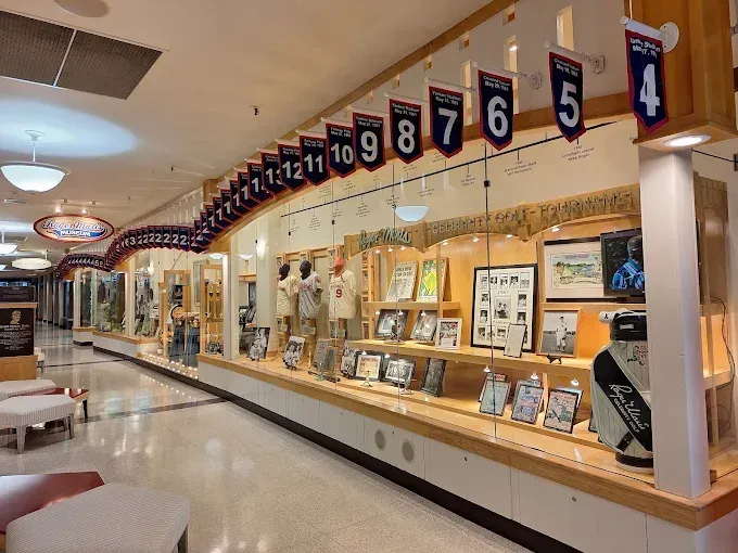 A display case in a corridor featuring numbered pennants, framed photos, and memorabilia from a university sports team.