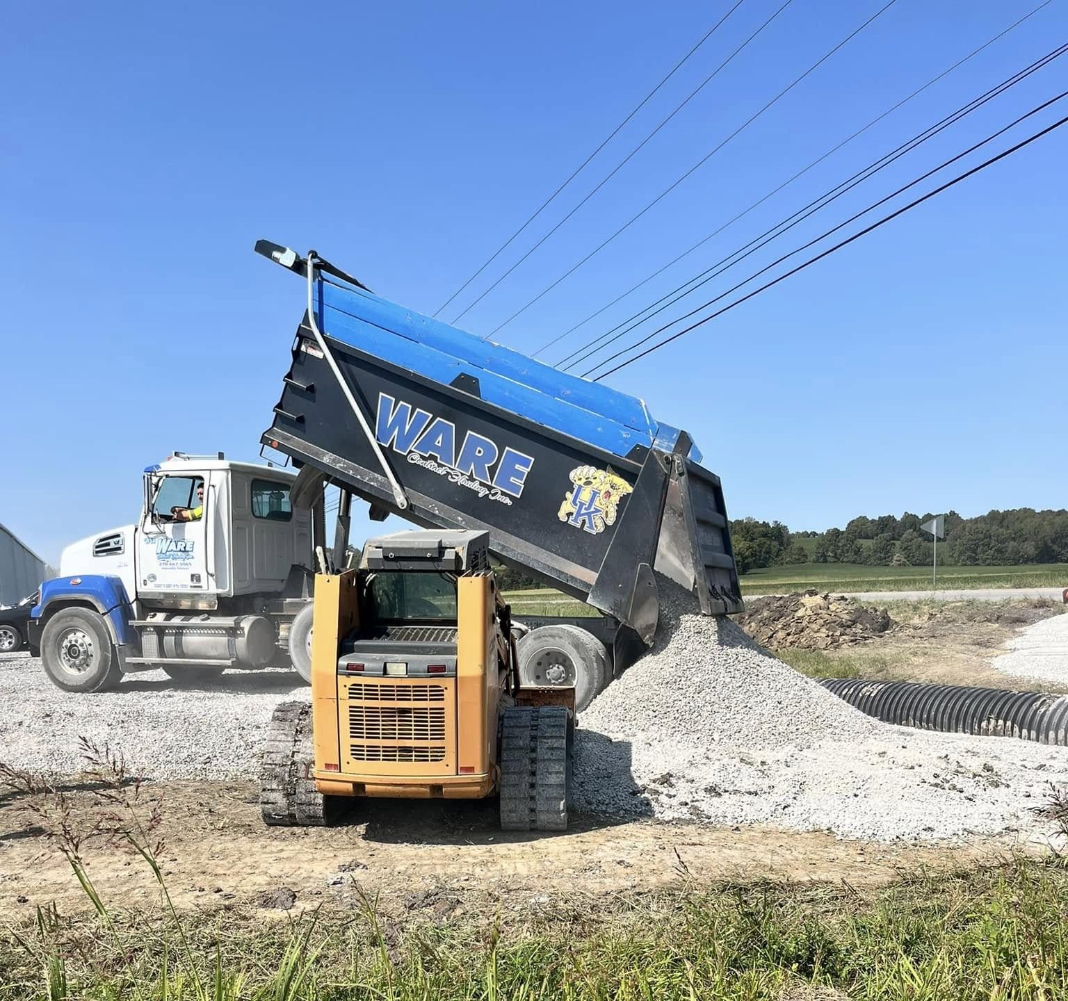 Construction worker in a vehicle wearing a hard hat, safety vest, and safety glasses.