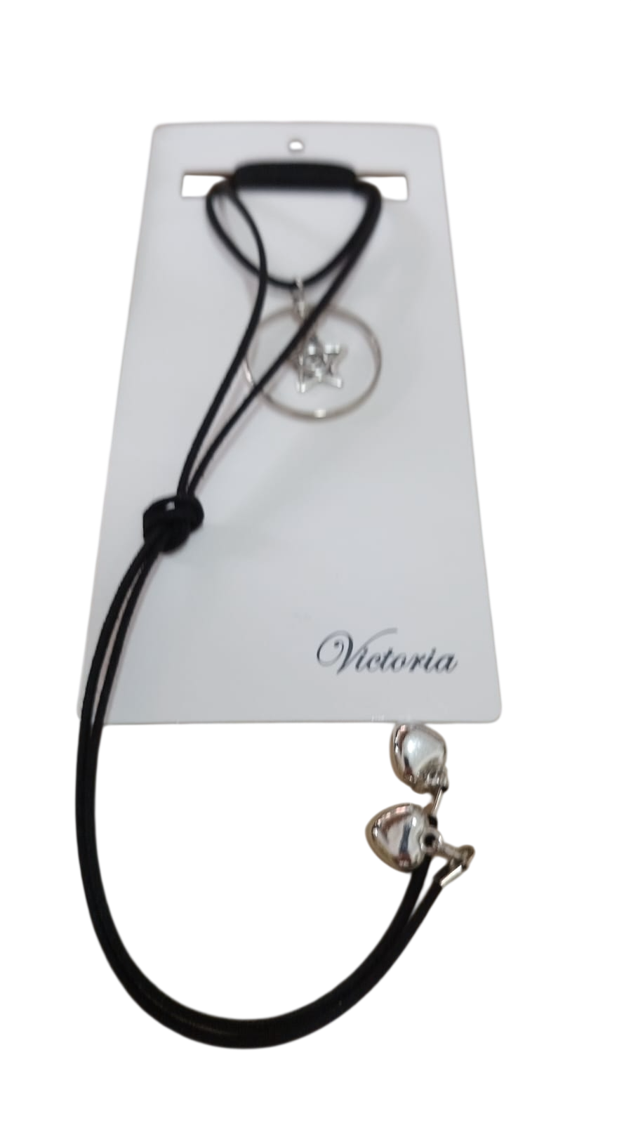 Collar con cordón negro, colgante y cierre plateados, presentado en una tarjeta Victoria blanca.