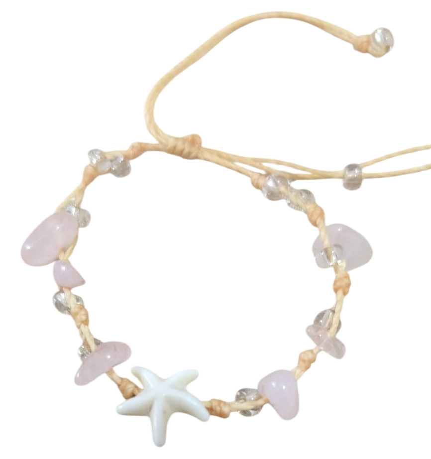 Pulsera con dije de estrella de mar con piedras de color rosa pálido y un cordón color canela sobre un fondo blanco.