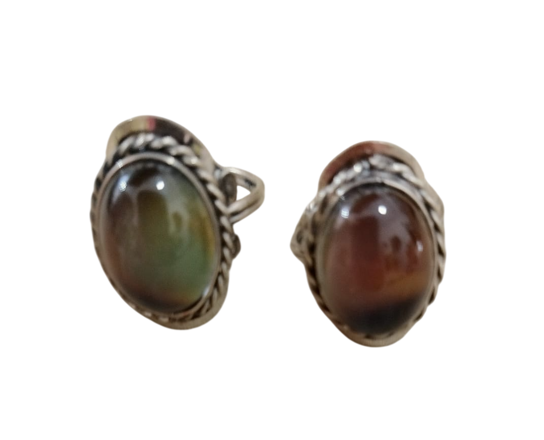 Par de pendientes ovalados con piedras preciosas y engastes de plata, uno de color verde parduzco