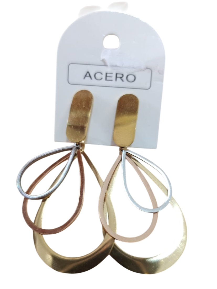 Pendientes colgantes geométricos en tono dorado sobre una tarjeta de presentación blanca con la etiqueta “ACERO”.