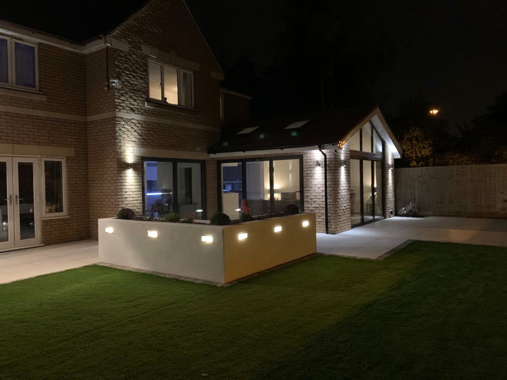 The backyard of a house is lit up at night.