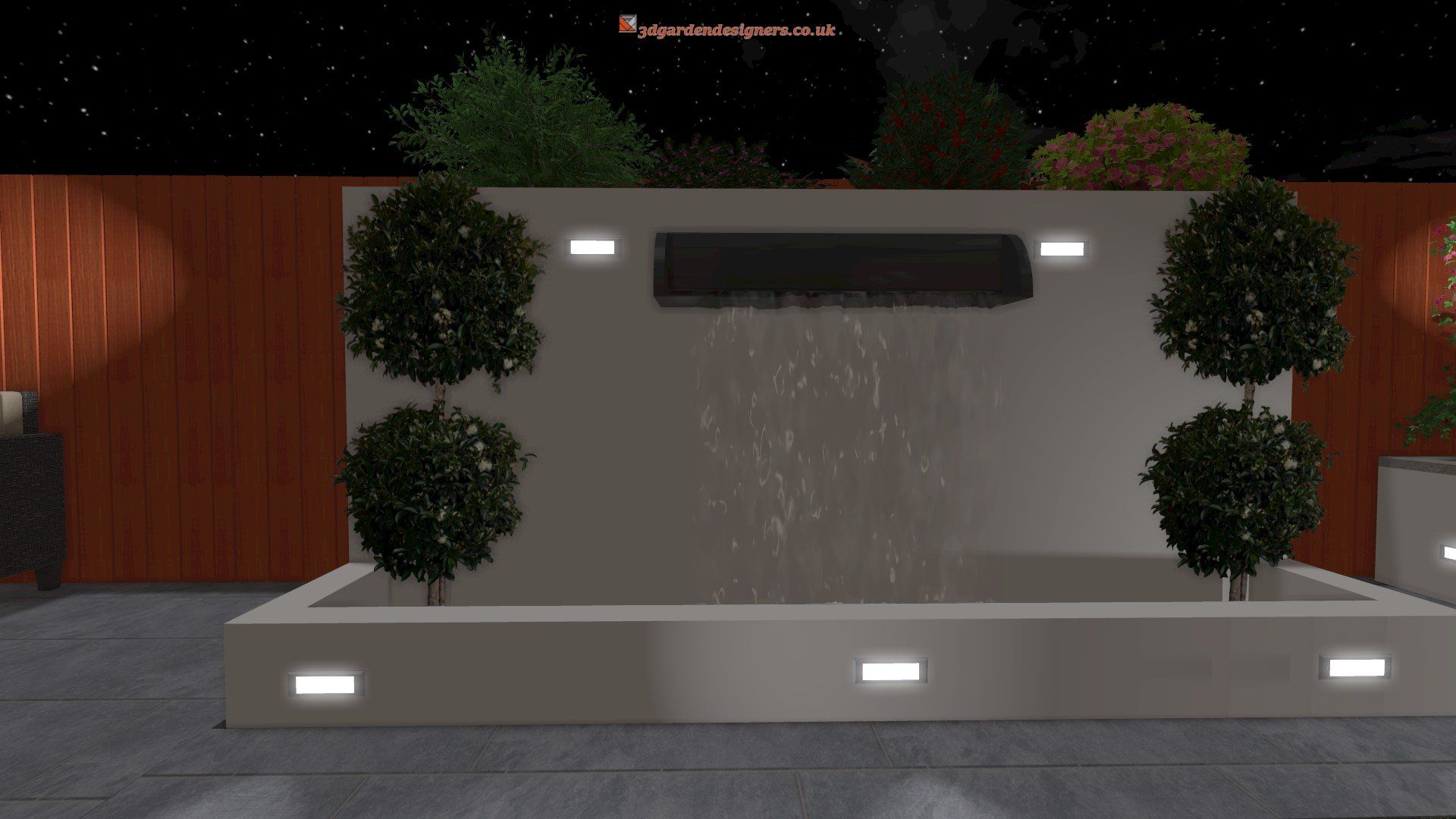 A waterfall is surrounded by trees in a backyard at night.