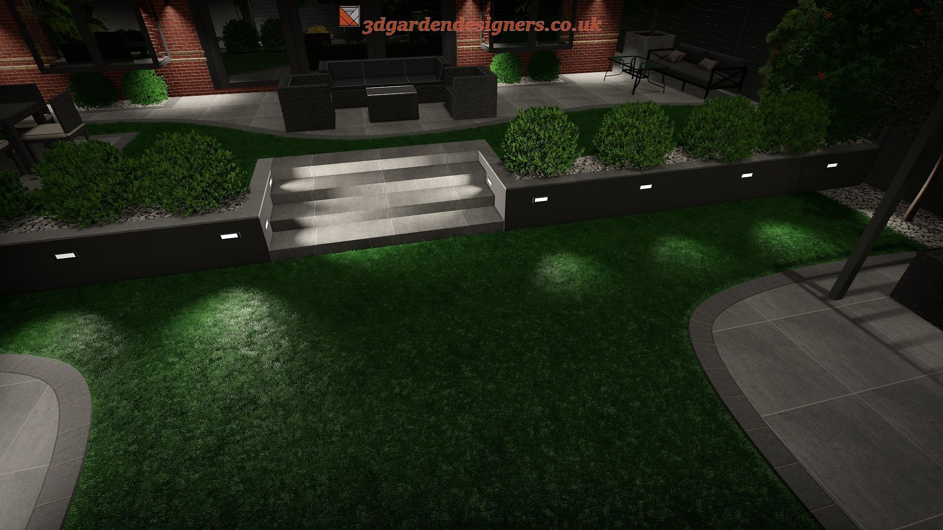 Night view of a well-lit backyard. Green lawn, bushes, steps, and seating area, with spotlights.