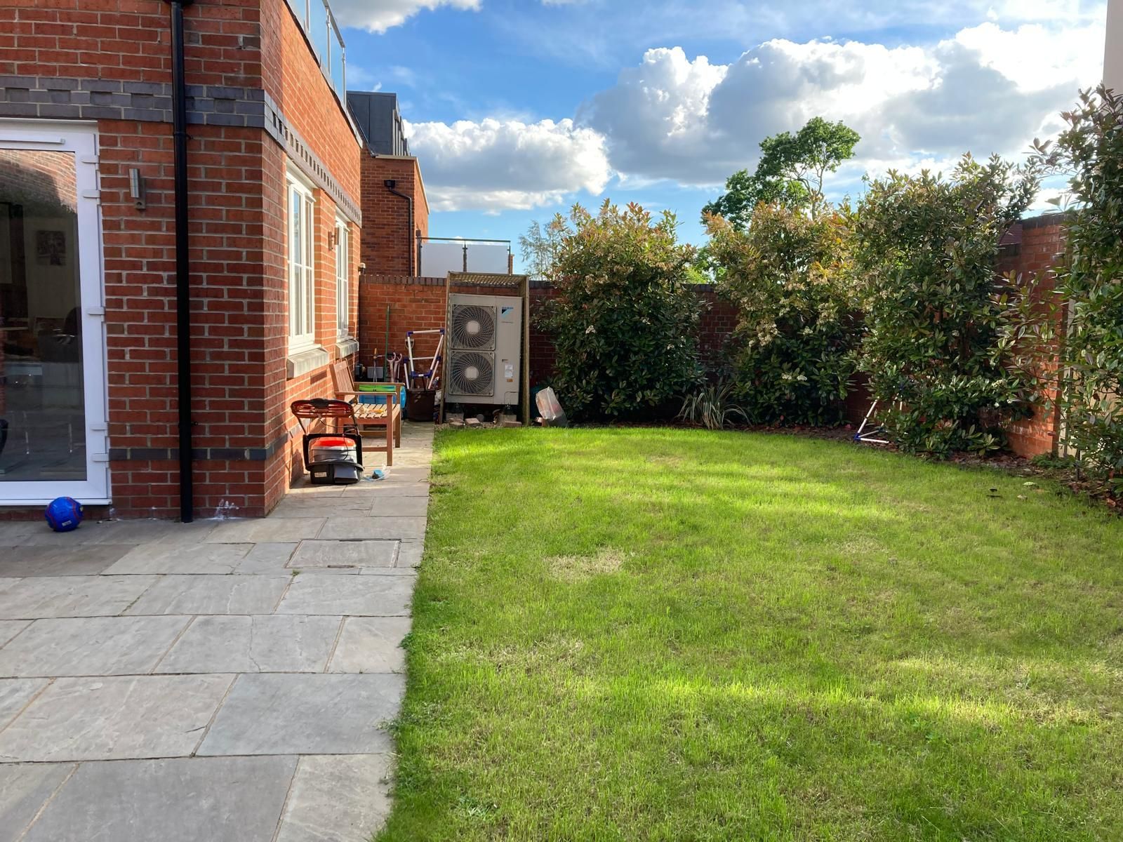 A brick house with a large lawn in front of it.