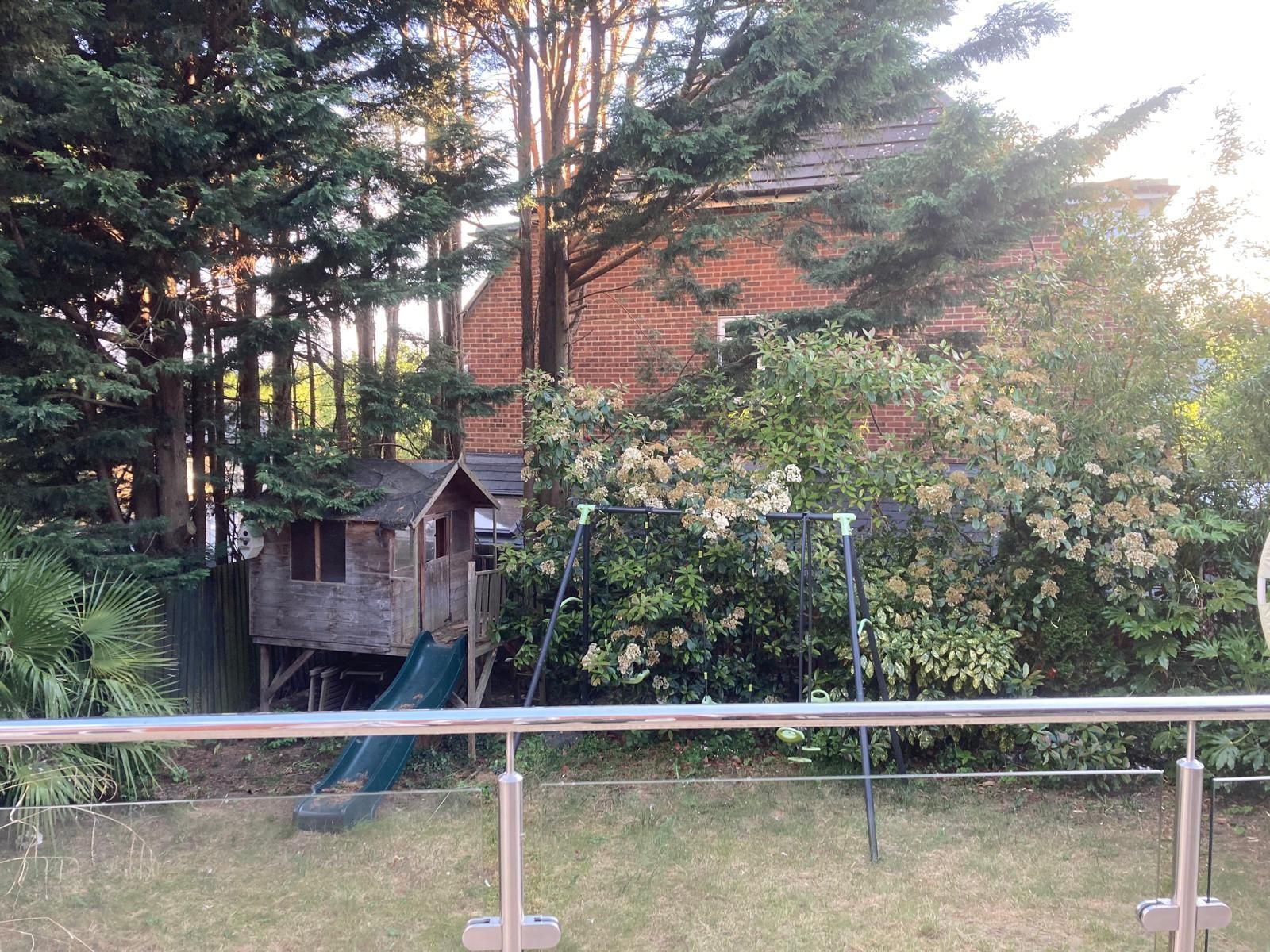 The back of a house with a lot of windows and a fence.