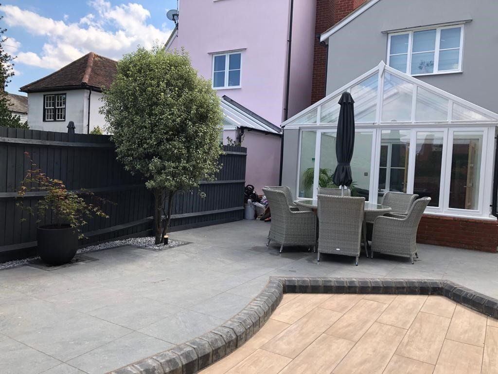 A patio with a table and chairs in front of a house.