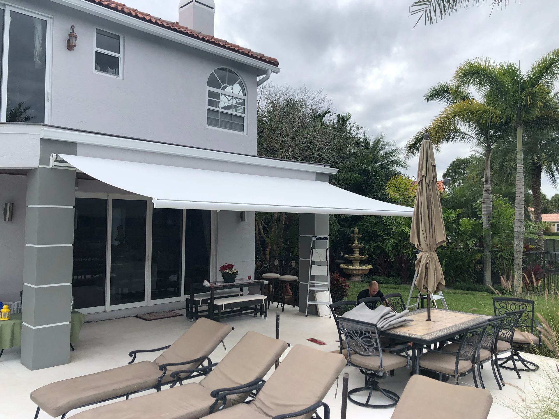 A patio with a table and chairs under an awning