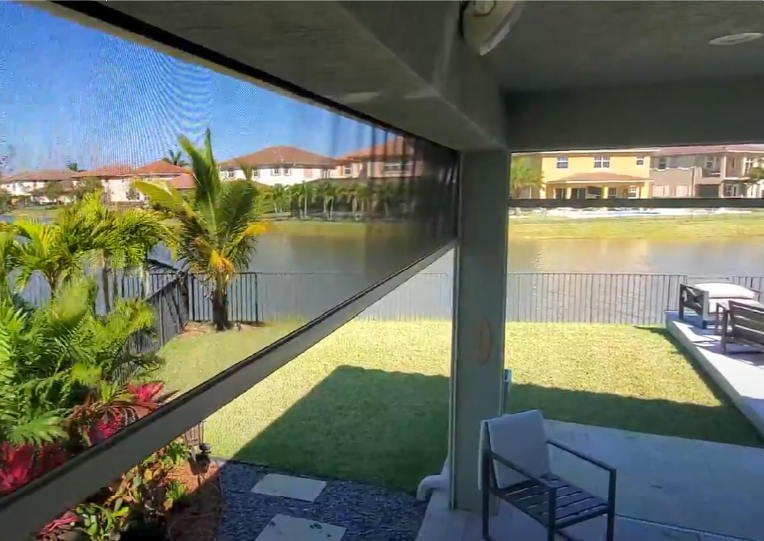 A view of a lake from a screened in porch.