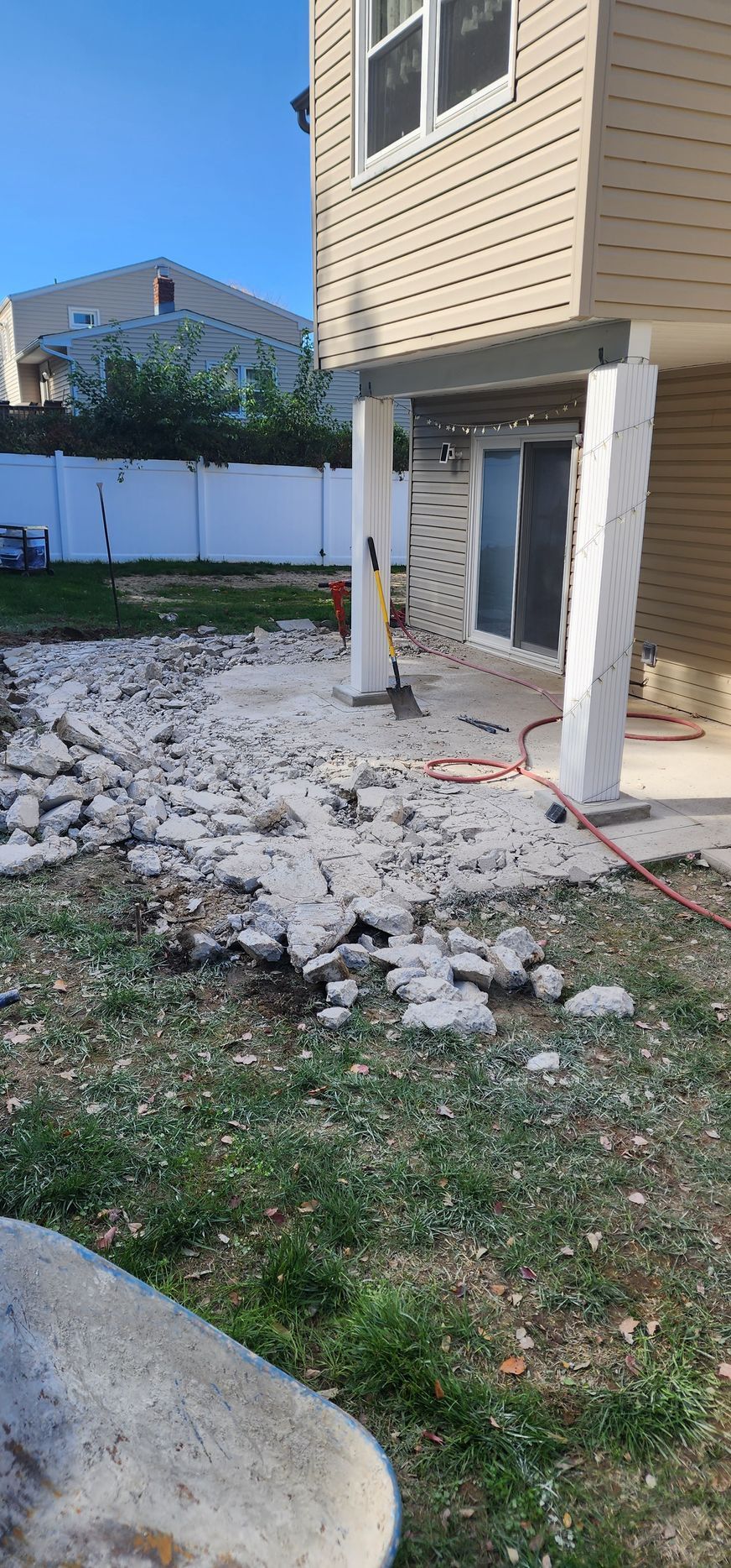 A house is being remodeled and a patio is being built in the backyard.