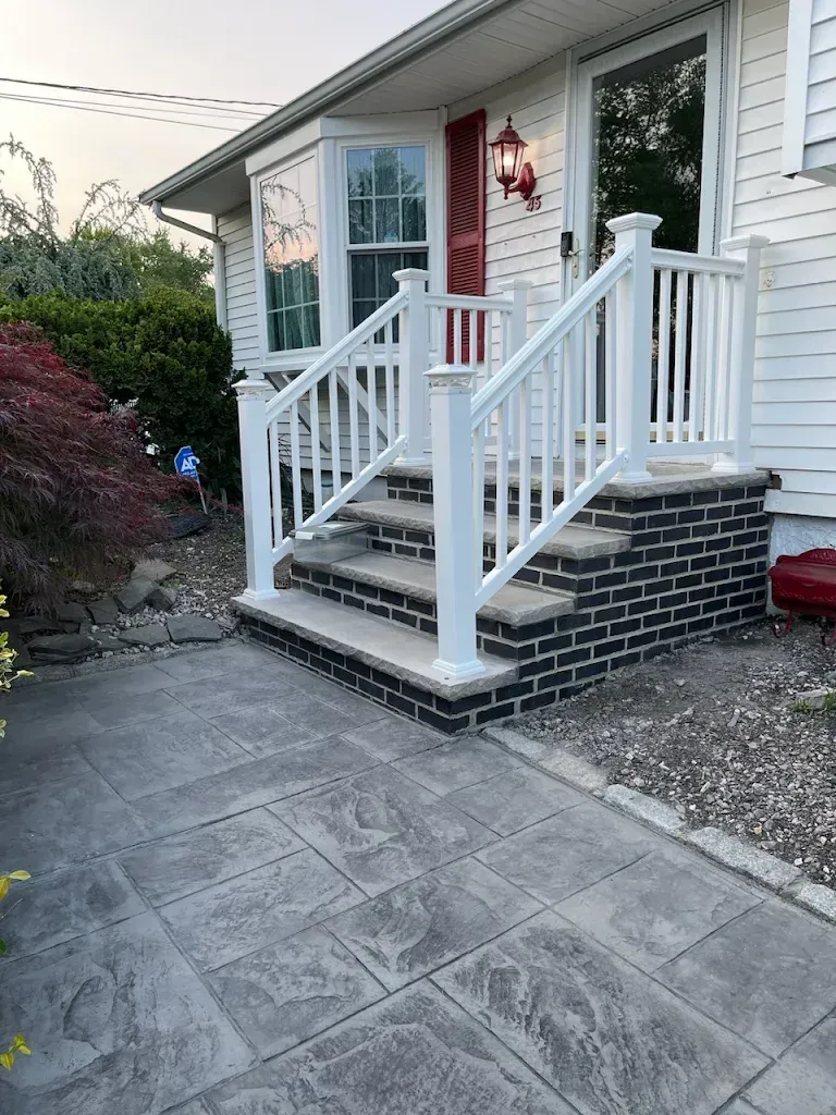 A concrete driveway in front of a house.