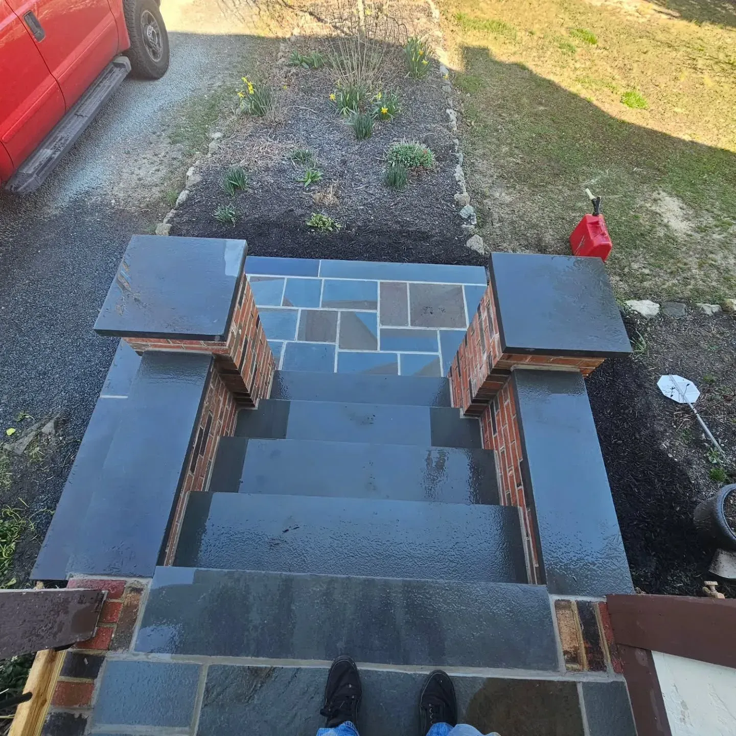 A person standing on a set of stairs next to a red truck