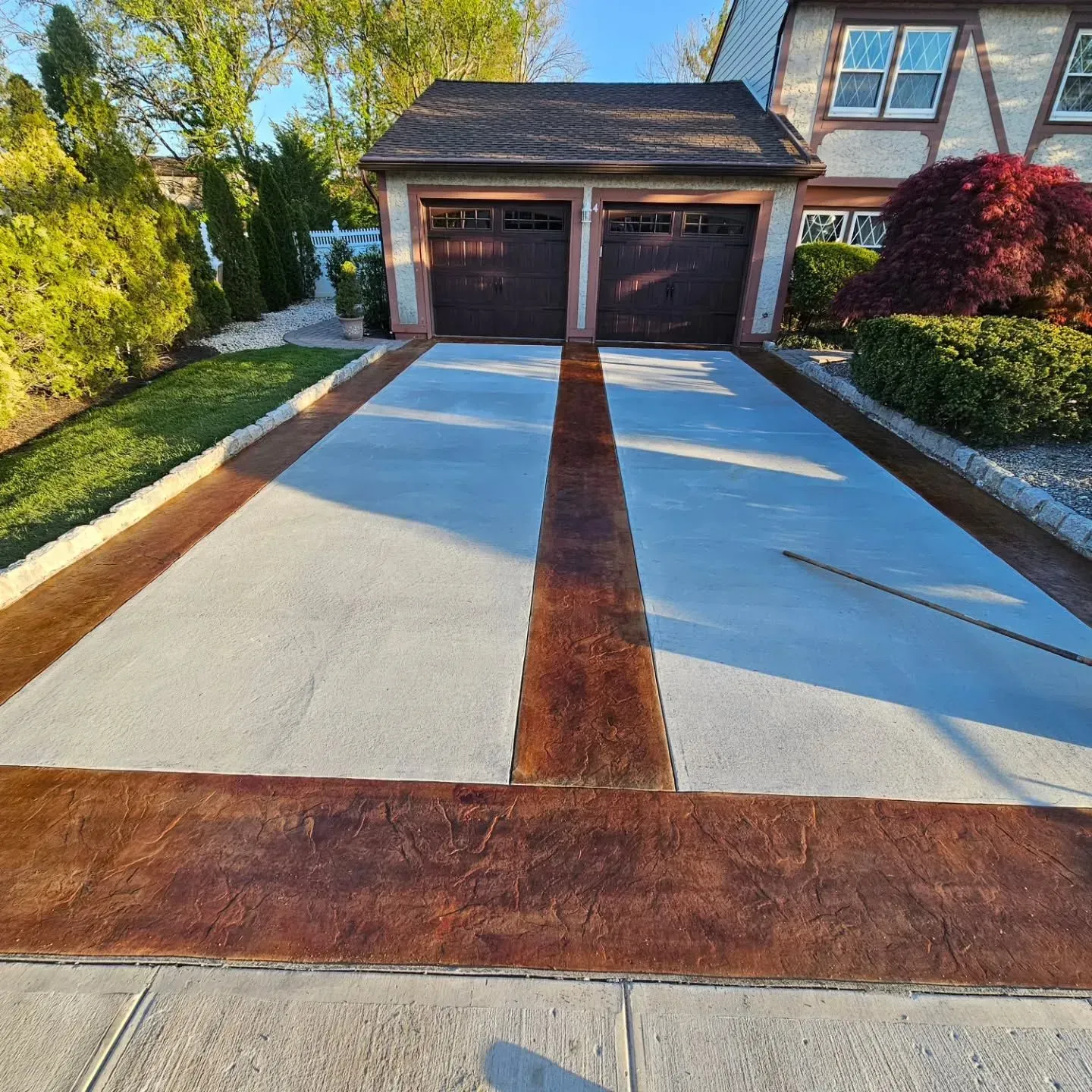 A driveway leading to a house with two garage doors
