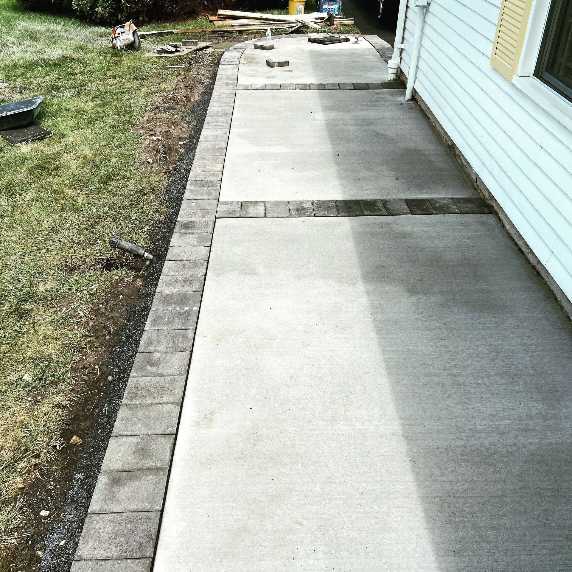 A sidewalk is being built in front of a house