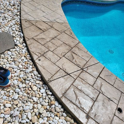 A pair of shoes are sitting next to a swimming pool
