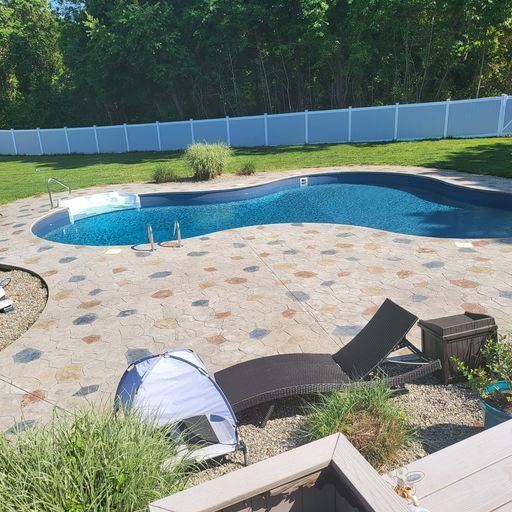 A large swimming pool with a white fence surrounding it