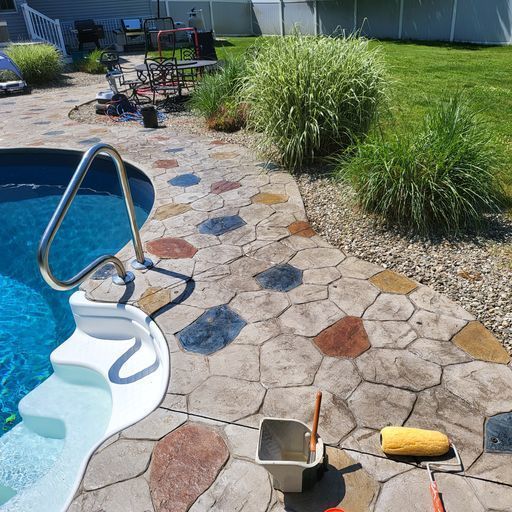 A concrete walkway leading to a pool is being painted.