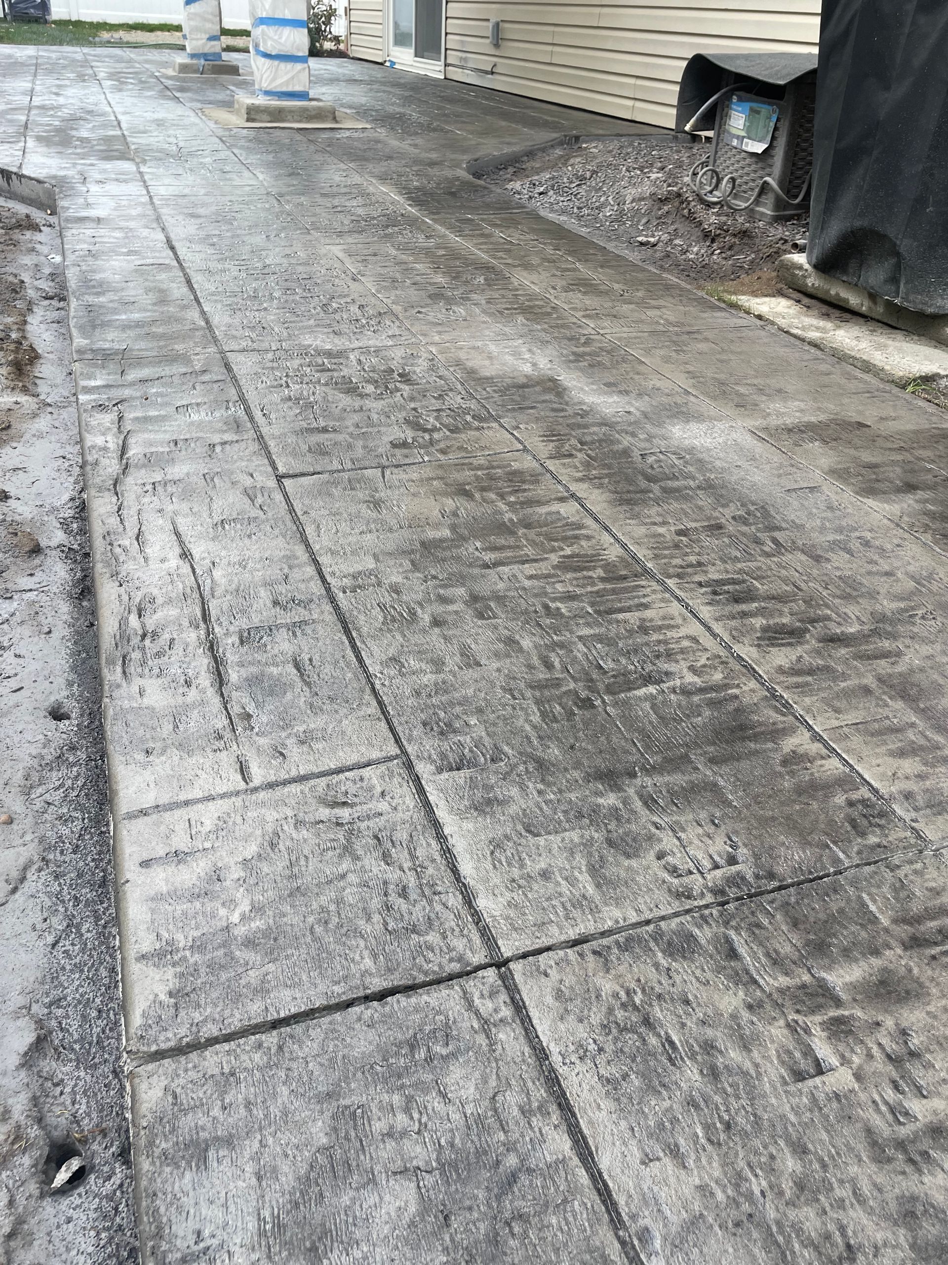 A concrete walkway is being built in front of a house.