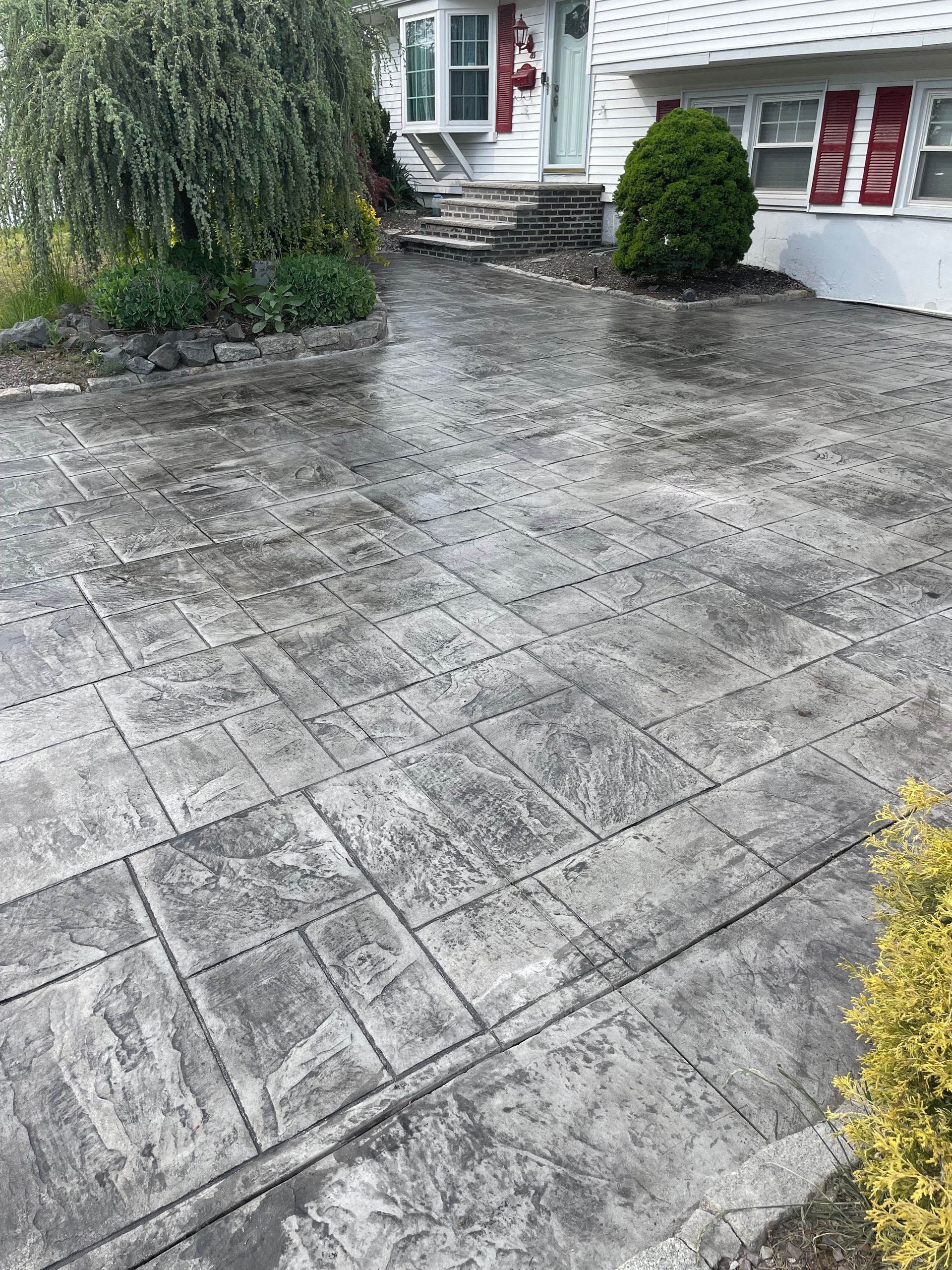 There is a concrete driveway in front of a house.