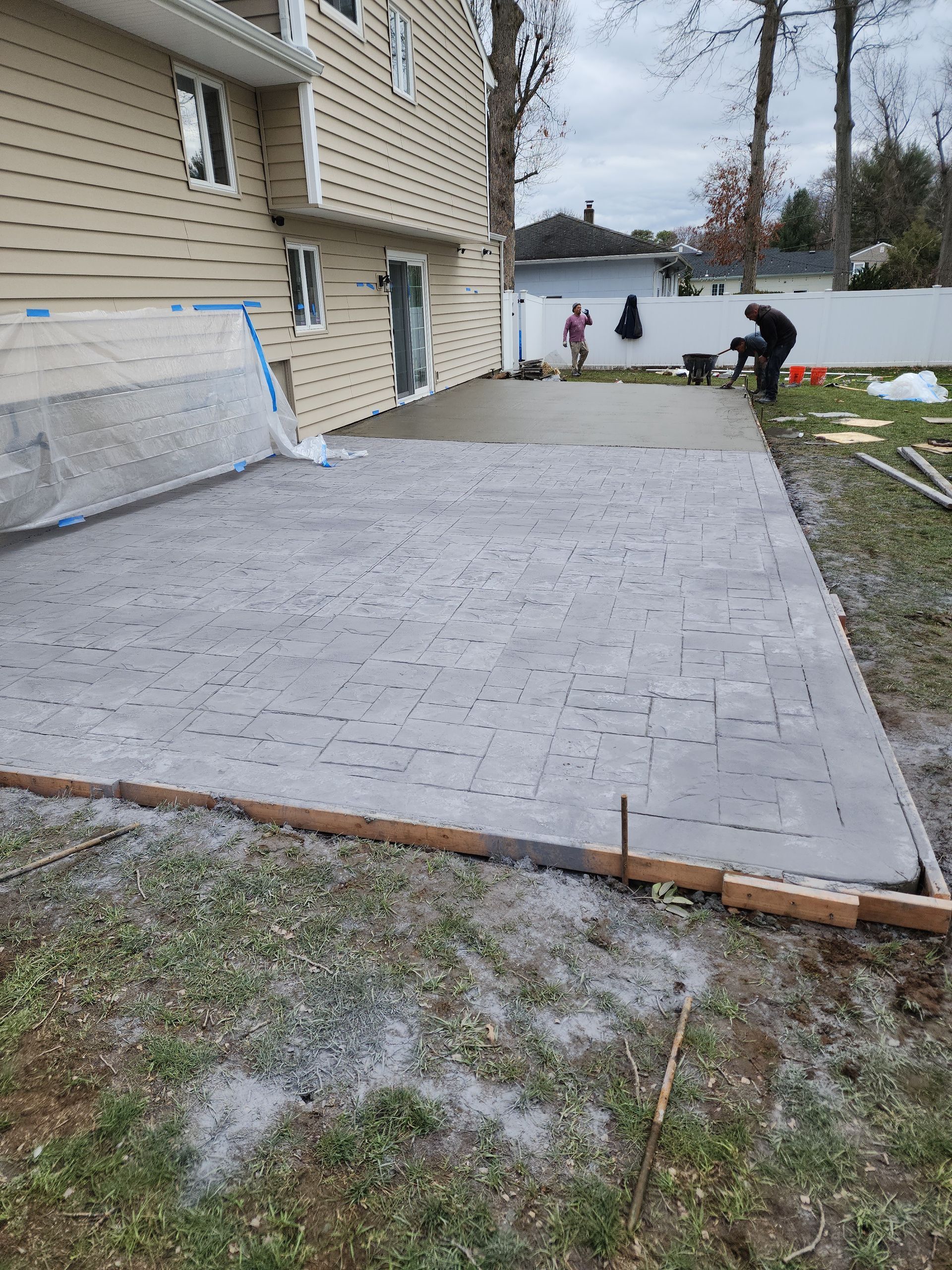 A concrete driveway is being built in front of a house.