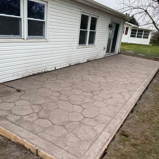 A concrete patio is being built in front of a white house.