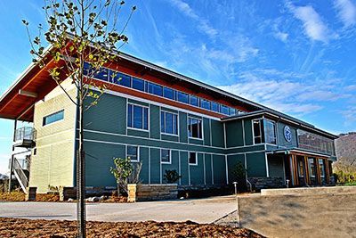 A large green building with a tree in front of it