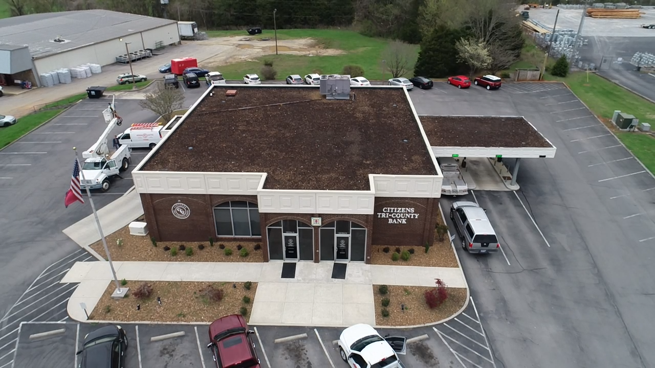 An aerial view of a building with cars parked in front of it