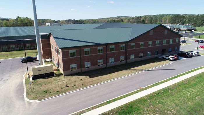 An aerial view of a large brick building with a green roof.