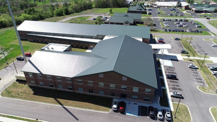 An aerial view of a large brick building with a green roof