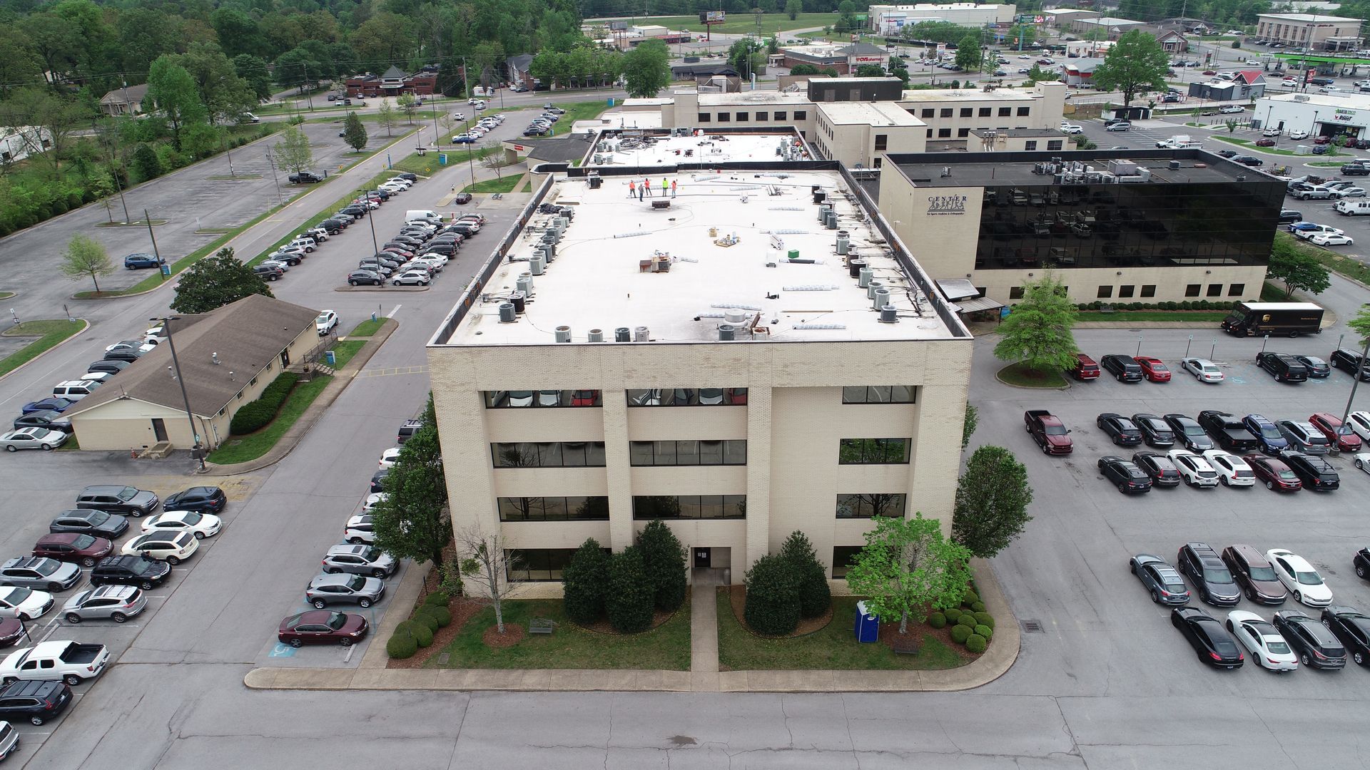 An aerial view of a large building with a parking lot in front of it